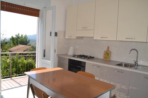 ディアーノ・カステッロにあるLa casa del Prussianoの白いキャビネット付きのキッチン、バルコニーが備わります。