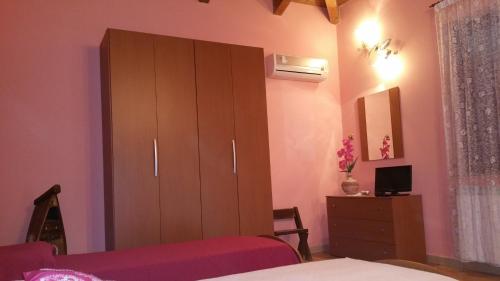 a bedroom with a large brown cabinet and a bed at Bed And Breakfast "ANNA" in Bagnara Calabra