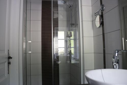 a bathroom with a sink and a glass shower at Auberge Lorraine in Le Valtin