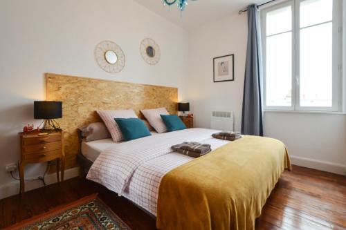 a bedroom with a large bed with a yellow blanket at La Mignonette in Épernay