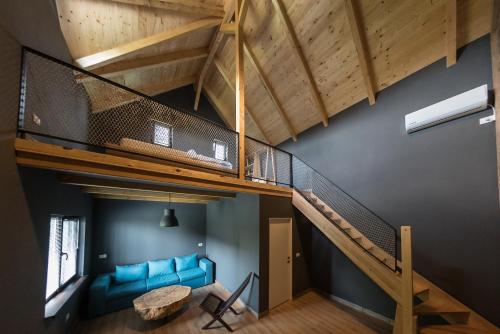 Loft con sofá azul y escalera en Casa Patru Anotimpuri, en Dunavăţu de Jos