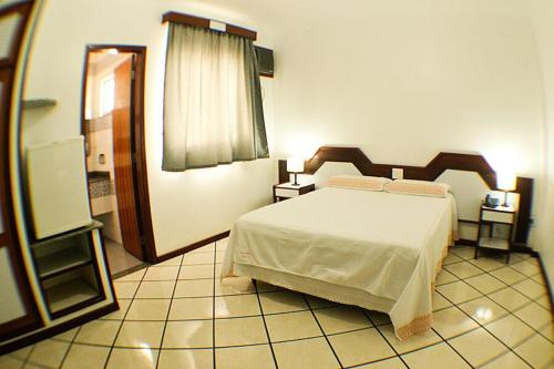 Shalako Hotel في فيتوريا دا كونكيستا: غرفة نوم فيها سرير ومرآة