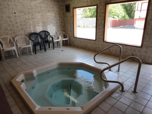 a jacuzzi tub in a room with chairs at Spanish Fiesta Resort in Osoyoos