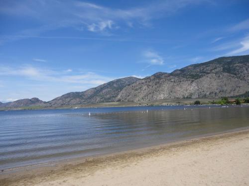 a view of a beach with mountains in the background at Spanish Fiesta Resort in Osoyoos