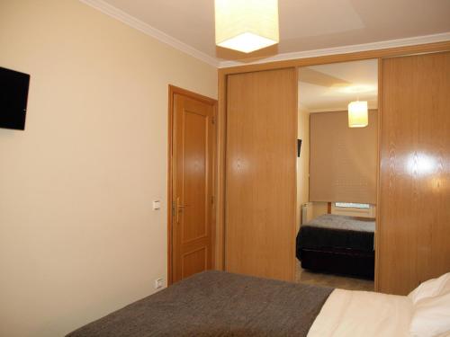 ein Schlafzimmer mit einem Bett und einem Spiegel in der Unterkunft Apartamento Compostela Playa in Vilagarcia de Arousa