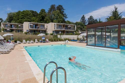 a person in a swimming pool at a resort at Résidence Odalys Le Clos Saint Michel in Chinon