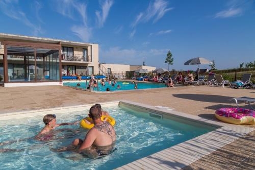 two people in the swimming pool at a resort at Résidence Odalys Le Clos Saint Michel in Chinon