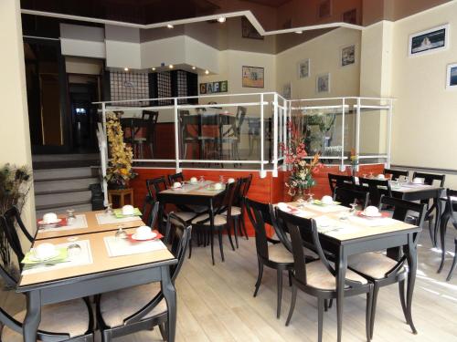 une salle à manger avec des tables et des chaises dans un restaurant dans l'établissement Hotel Le Boischaut - Citotel Chateauroux, à Châteauroux