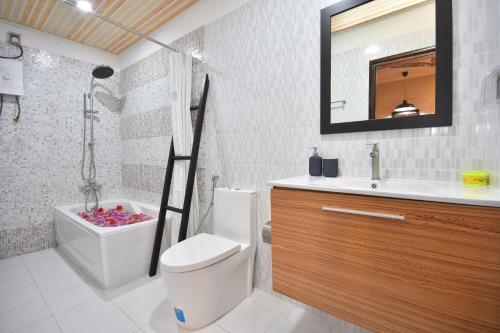 a bathroom with a toilet and a sink and a tub at Beach Veli in Ukulhas