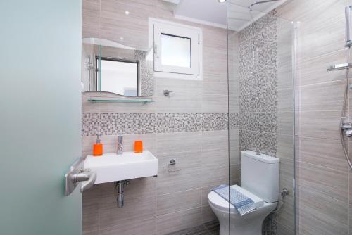 a bathroom with a toilet and a sink and a shower at Asteria Studios in Potos