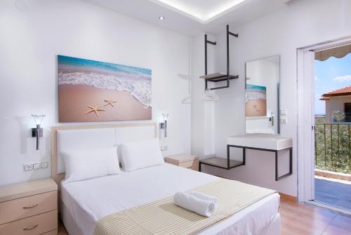 a white bedroom with a bed and a bathroom at Asteria Studios in Potos