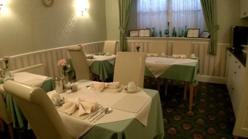 a dining room with two tables with green table cloth at Crimdon Dene in Torquay