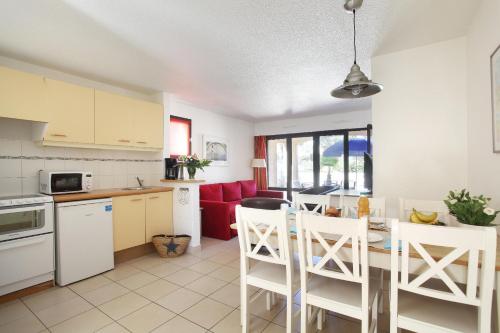 une cuisine et un salon avec une table et des chaises dans l'établissement Résidence Odalys Saint Loup, au Cap d'Agde