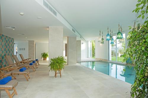 a lobby with a pool and chairs and a swimming pool at Myseahouse Flamingo - Adults Only 4* Sup in Playa de Palma