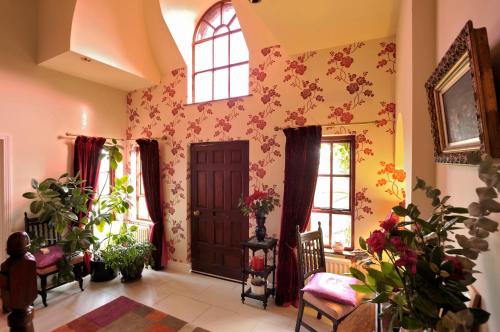 a living room with a door and flowers on the wall at Pinewood Lodge Guest House in Omagh