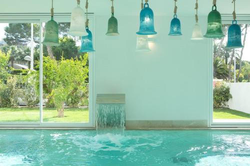 einen Pool mit Wasser, der in ein Zimmer mit Hängelampen strömt in der Unterkunft Myseahouse Flamingo - Adults Only 4* Sup in Playa de Palma