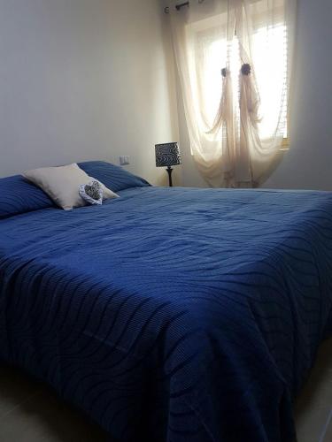 niebieskie łóżko w sypialni z oknem w obiekcie Fiore di Loto w mieście Limatola