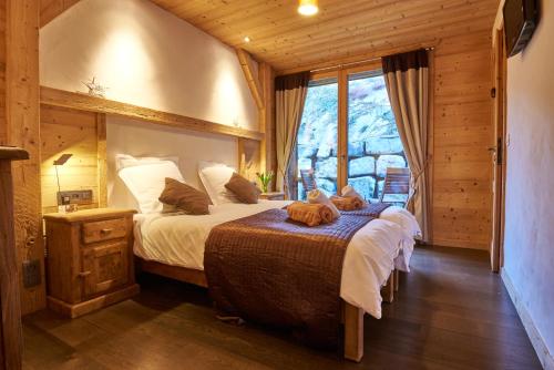 a bedroom with a large bed and a window at Chalet Virolet in Les Gets