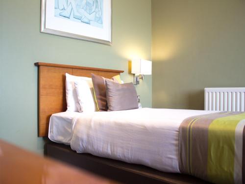 a bedroom with a bed with white sheets and pillows at Sandbanks Hotel in Poole