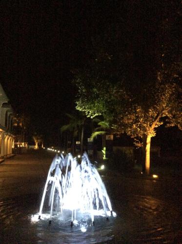 a group of water fountains on a street at night at Amaretto Hostel in Surat Thani