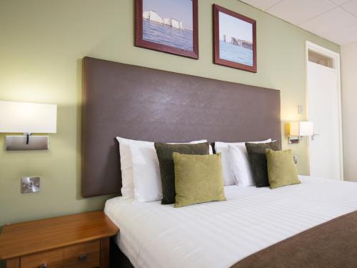 a bedroom with a large bed with white sheets and pillows at Sandbanks Hotel in Poole