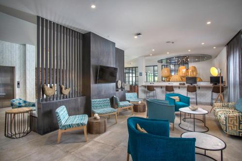 a lobby with blue chairs and tables and a bar at Catalonia Royal La Romana Adults Only - All Inclusive in Bayahibe