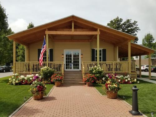 a house with a flag and flowers in front of it at The Railroad Inn in Cooperstown