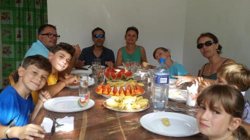 un gruppo di persone seduti intorno a un tavolo con cibo di Rich Resort & Restaurant a Anuradhapura