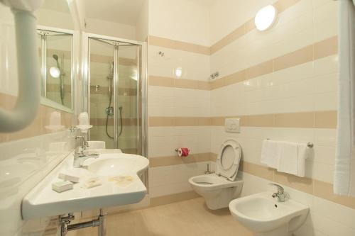 シルヴィ・マリーナにあるHotel Rivieraのバスルーム(洗面台2台、トイレ、シャワー付)
