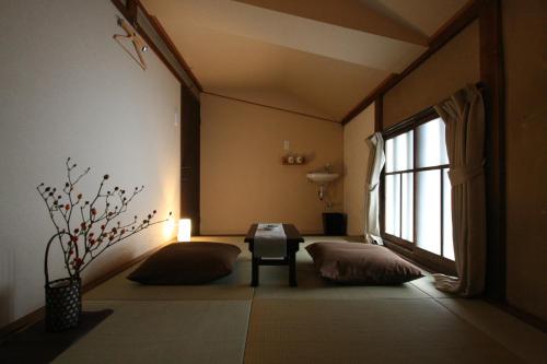 Habitación con 2 almohadas, mesa y ventana en HARUYA Naramachi, en Nara