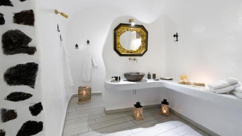 a bathroom with a tub and a sink and a mirror at Fira Deep Blue Suites in Fira