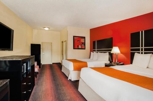 two beds in a hotel room with red walls at Howard Johnson by Wyndham North Plainfield in North Plainfield
