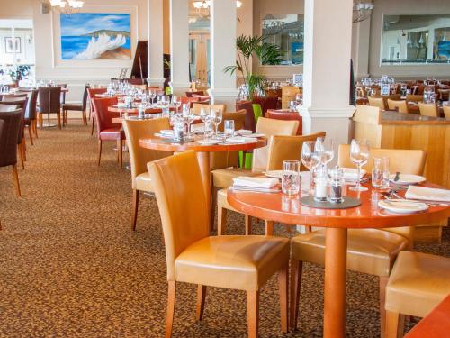 a dining room with wooden tables and chairs at Sandbanks Hotel in Poole