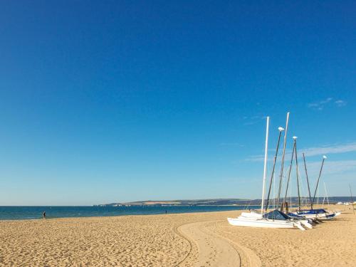a group of boats sitting on a sandy beach at Sandbanks Hotel in Poole