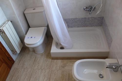 a bathroom with a toilet and a tub and a sink at Hotel Albohera in Santiago de la Ribera