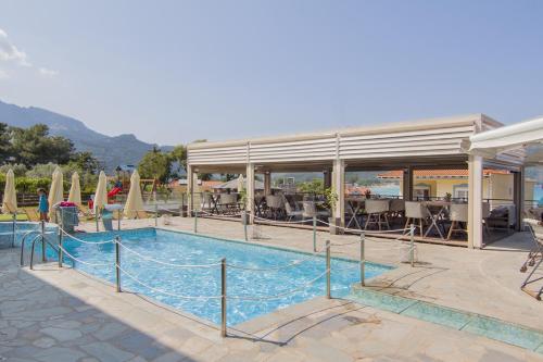 a swimming pool with a slide in front of a resort at Ntinas Filoxenia Hotel & Spa in Skala Potamias