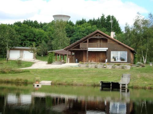 a cabin by a lake with a water tower at Lieux-au-lac in Augignac