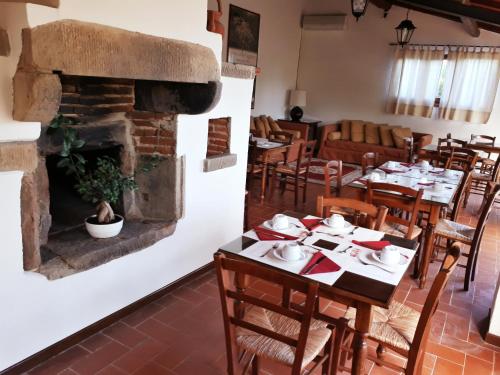 a dining room with tables and a fireplace at Agriturismo Antico Borgo Poggitazzi in Loro Ciuffenna