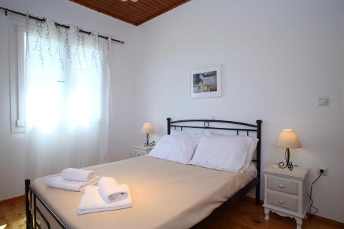 a bedroom with a bed with two towels on it at Pine House with Sea View in Lefkada Town
