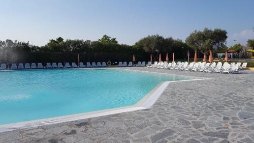 a swimming pool with chairs and lawn chairs at The Garda Village in Sirmione