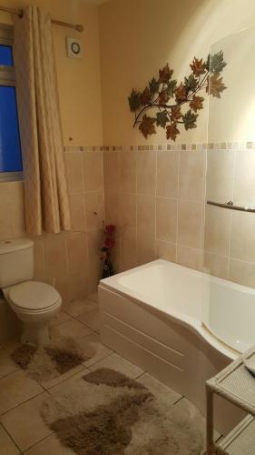 a bathroom with a white tub and a toilet at Greencastle in Kilkeel