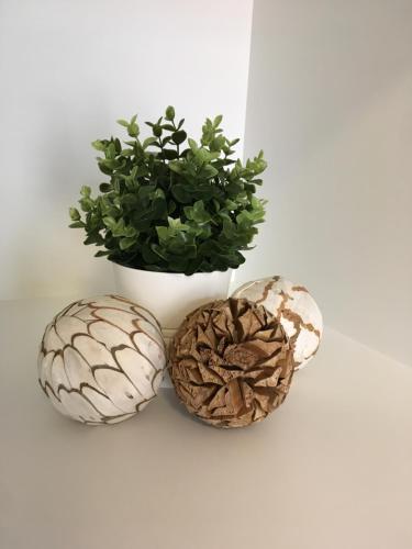 three decorative balls on a table with a plant at Apartmány Pinie Lipno in Lipno nad Vltavou