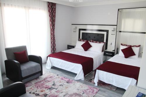 a hotel room with two beds and a chair at Kural Pansiyon in Amasra