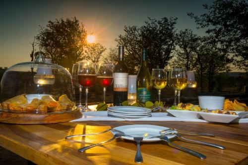 a table with glasses of wine and a plate of food at Ongava Tented Camp in Okaukuejo