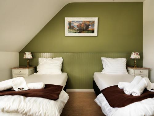 two beds in a room with green walls at Hotel Apartments Belgium - HAB 2 in Westerlo
