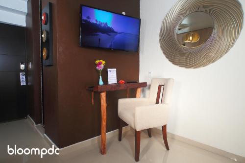 a room with a table and a chair and a mirror at Bloom! exclusive boutique b&b in Playa del Carmen