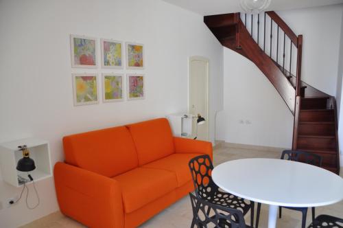 a living room with an orange couch and a table at Porta Barsento in Putignano