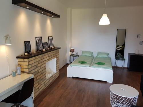 a bedroom with a bed and a brick fireplace at 27 Shades of Green (4 bedroom 3 Bath Sunny Central) in Budapest