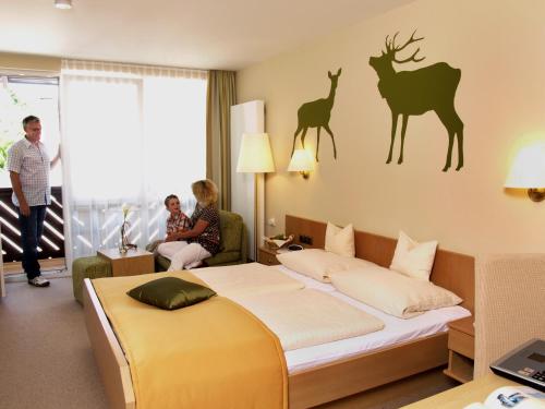 um quarto de hotel com uma cama e pessoas num quarto em Hotel Haus Wiesengrund em Hallenberg