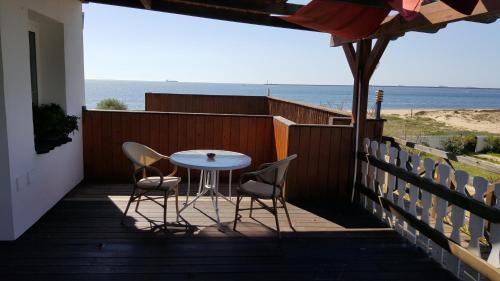 una mesa y 2 sillas en un balcón con vistas al océano en Hostal Playa Mazagon (El Remo), en Mazagón